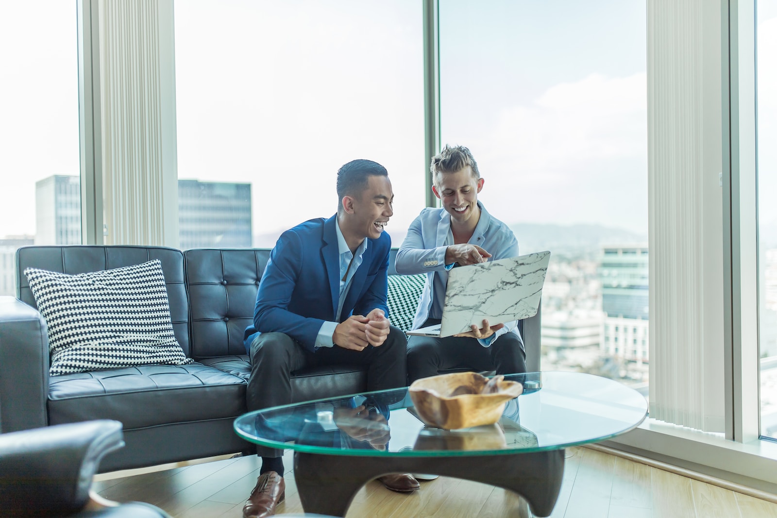 two men in suit sitting on sofa